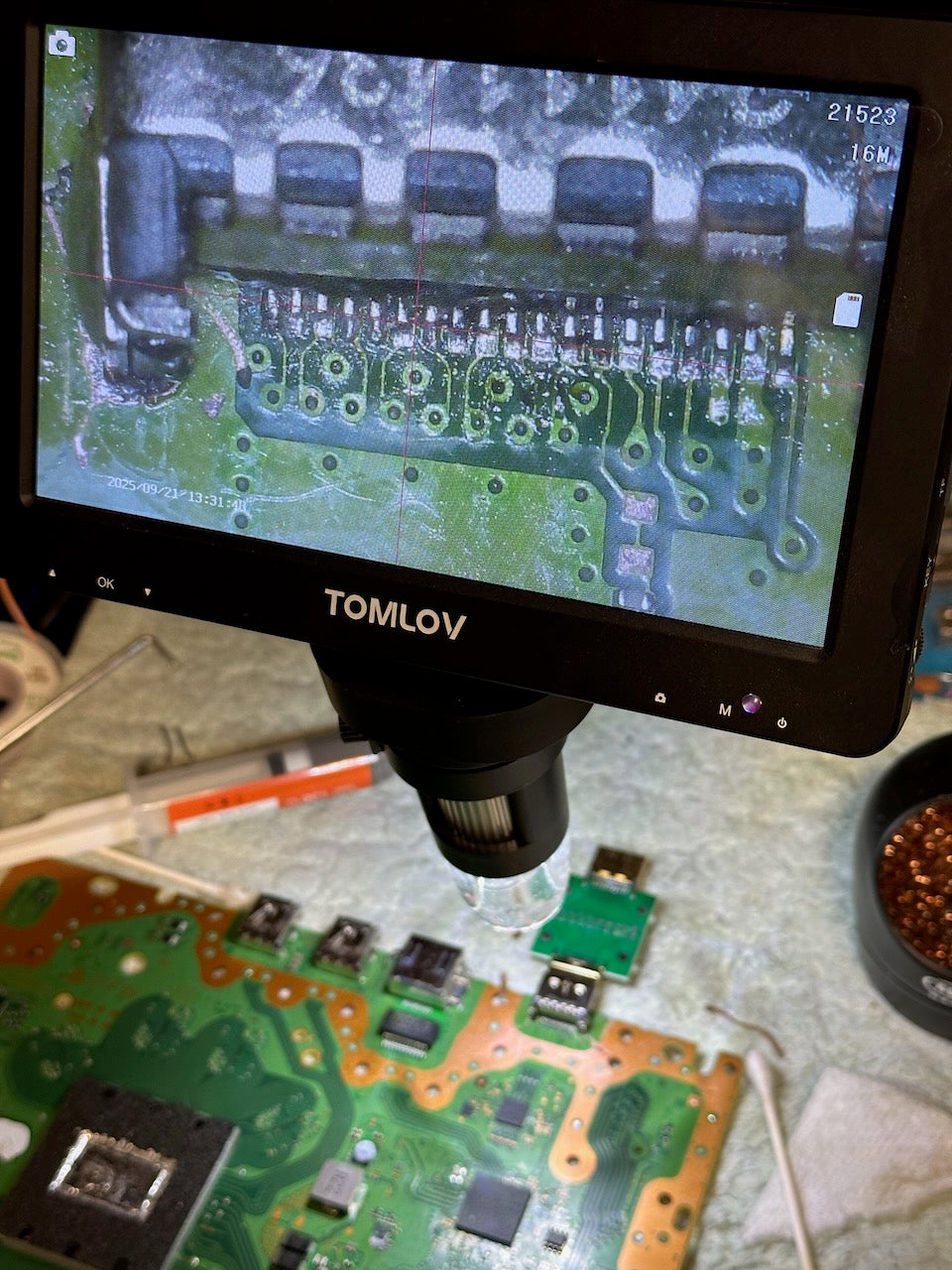 TOMLOV digital microscope displaying a close-up of a circuit board